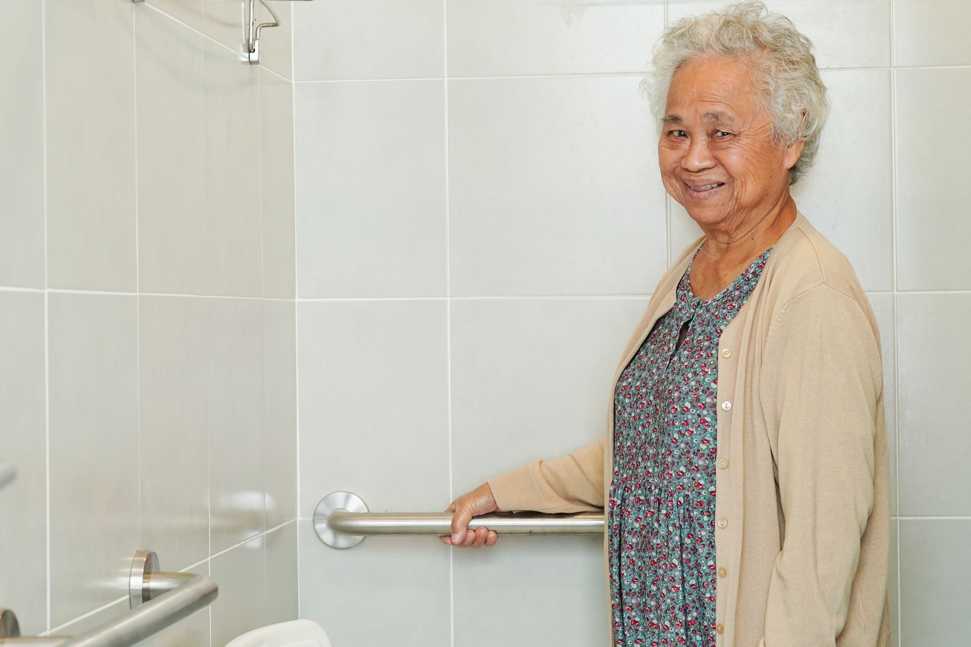 Asian elderly old woman patient use toilet support rail in bathroom, handrail safety grab bar, security in nursing hospital.